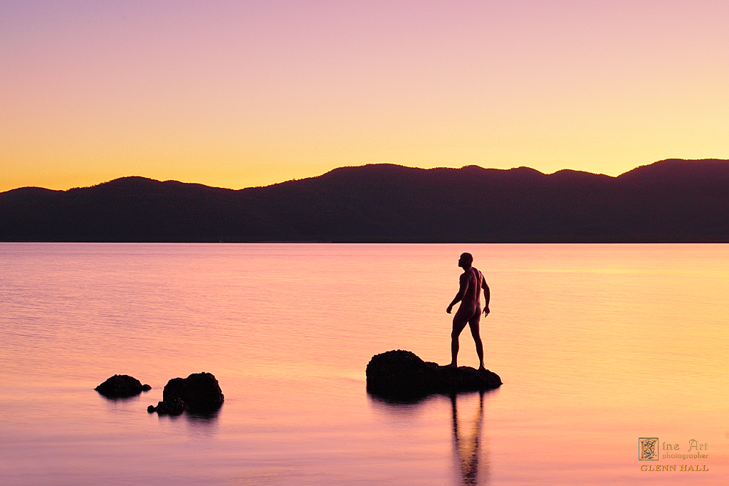 Alone — figure silhouetted against the first ray of sunrise over the ocean
